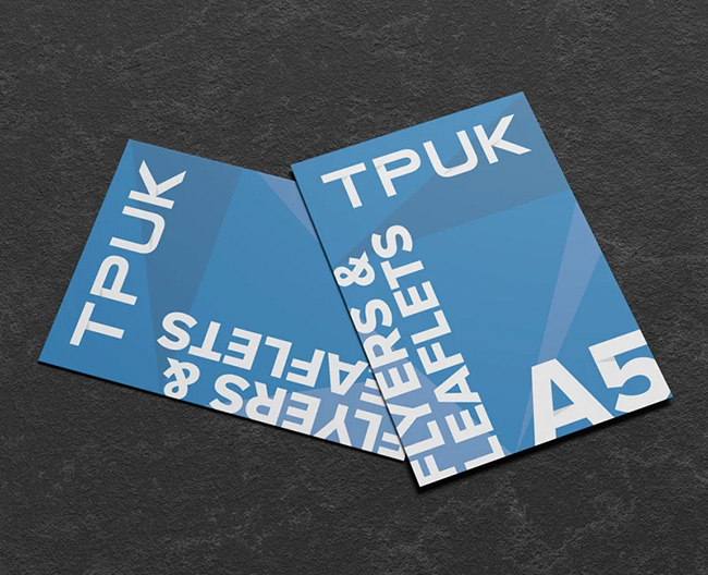 Pair of angled custom printed A5 flyers and leaflets by TradePrintingUK.com on dark grey background